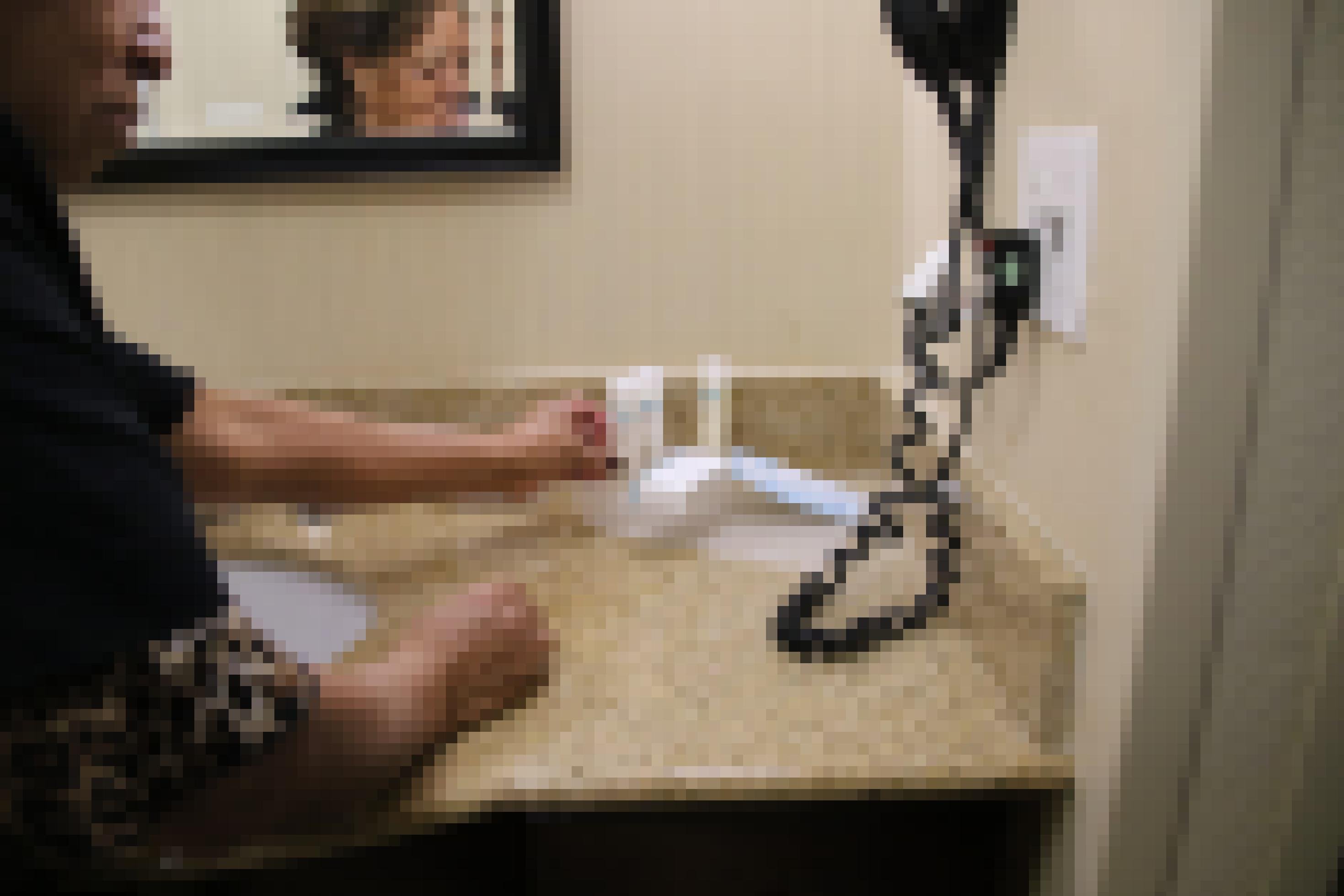 Ein Zimmermädchen putzt einen Spiegel in einem Hotelzimmer
